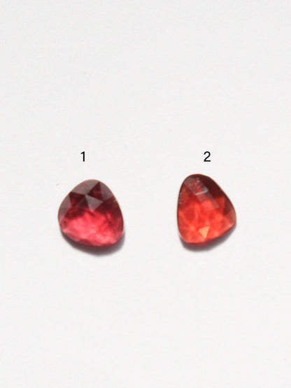 Granates de talla rosa numerados, sobre superficie blanca.