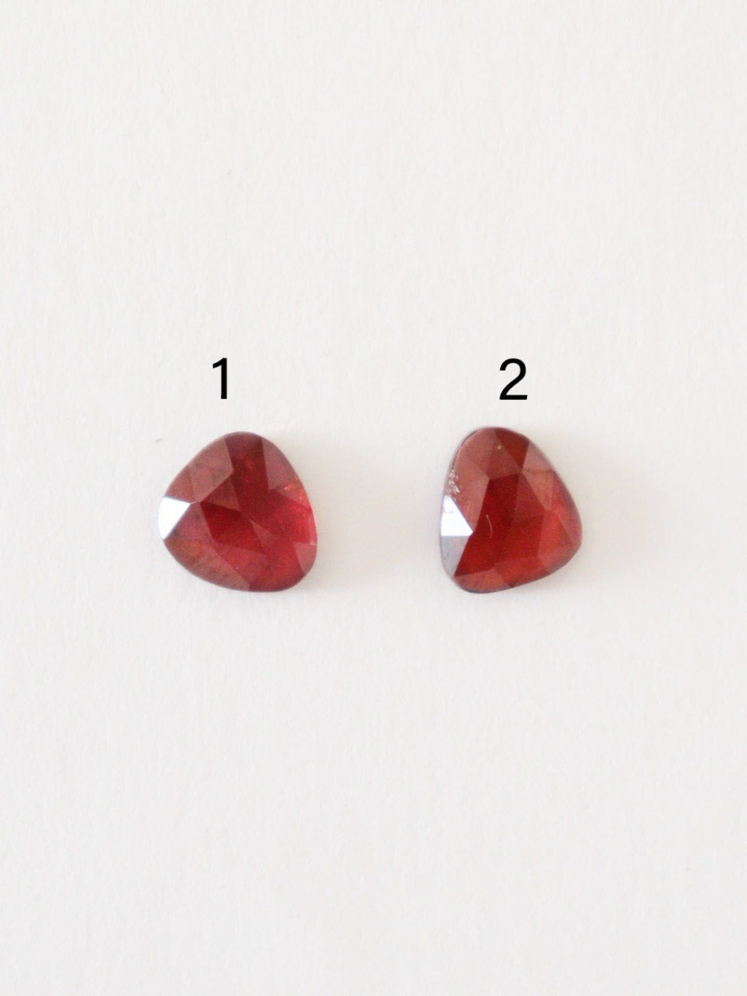 Granates de talla rosa numerados, sobre superficie blanca.