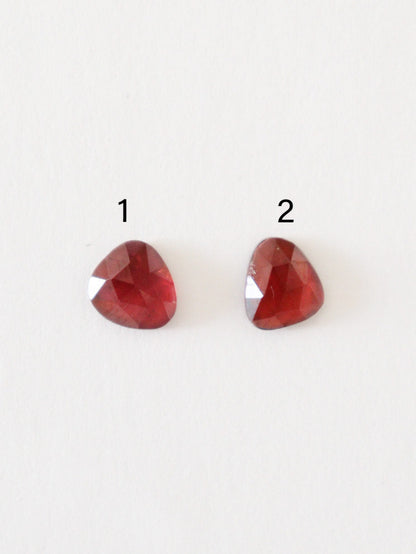 Granates de talla rosa numerados, sobre superficie blanca.