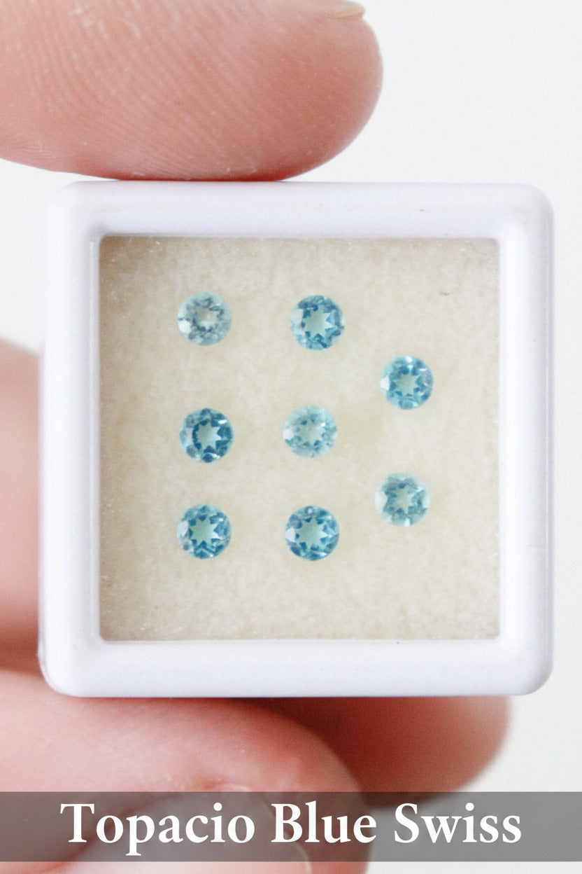 Topacios blue swiss de talla redonda de 3mm, organizados en una caja expositora.